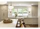 Well-lit kitchen with white cabinets, a farmhouse sink, island seating, and modern pendant lights at 7105 Sylvan Ridge Rd, Indianapolis, IN 46240