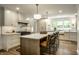 Bright kitchen with stainless appliances, island seating, white cabinetry, and stylish pendant lighting at 7105 Sylvan Ridge Rd, Indianapolis, IN 46240