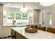 Bright kitchen features a large island, farmhouse sink beneath a window, and modern lighting at 7105 Sylvan Ridge Rd, Indianapolis, IN 46240