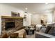 Cozy living room featuring a brick fireplace, wood floors, and comfortable gray sofa with views to the kitchen at 7105 Sylvan Ridge Rd, Indianapolis, IN 46240