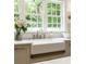 The undermount farmhouse sink features a bridge faucet and a large window overlooking the green yard at 7105 Sylvan Ridge Rd, Indianapolis, IN 46240