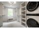 Spacious walk-in closet with modern washer dryer and custom shelves and storage at 7105 Sylvan Ridge Rd, Indianapolis, IN 46240