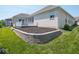 Landscaped backyard featuring a patio, green grass, and decorative retaining wall with garden beds at 7329 Birch Leaf Dr, Indianapolis, IN 46259