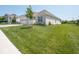 Beautifully landscaped front yard with lush green lawn, and a brick single-story home with attached garage at 7329 Birch Leaf Dr, Indianapolis, IN 46259