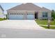 A charming single-story home features a brick facade, a well-manicured lawn, and an attached two-car garage at 7329 Birch Leaf Dr, Indianapolis, IN 46259