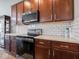 A close-up view shows the stainless steel range, microwave, wood cabinets, and quartz countertops at 7329 Birch Leaf Dr, Indianapolis, IN 46259