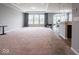 A spacious living room featuring a wall of windows, and neutral carpet at 7329 Birch Leaf Dr, Indianapolis, IN 46259