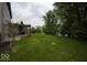 The large, well-manicured backyard features a wooden pergola, mature trees, and verdant lawn in a well-kept neighborhood at 7657 Wheatgrass Ln, Noblesville, IN 46062