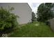 The beautiful backyard includes lush green grass, a mature shade tree, and the home's vinyl siding at 7657 Wheatgrass Ln, Noblesville, IN 46062