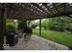 An outdoor patio includes ample seating and an outdoor grill beneath a wooden pergola, with a view of the lawn at 7657 Wheatgrass Ln, Noblesville, IN 46062
