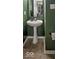 Small bathroom features a pedestal sink, decorative mirror, and dark green walls at 7657 Wheatgrass Ln, Noblesville, IN 46062