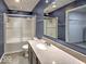 Well-lit bathroom with modern vanity, shower with glass door, and tile floors at 7657 Wheatgrass Ln, Noblesville, IN 46062
