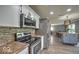 Well-equipped kitchen featuring stainless steel appliances, stylish tile backsplash, and an island for extra space at 7657 Wheatgrass Ln, Noblesville, IN 46062