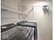 Functional laundry room with modern washer and dryer, and ample shelving for storage at 7657 Wheatgrass Ln, Noblesville, IN 46062