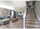 Cozy living room featuring neutral tones, hardwood floors, and staircase access at 7657 Wheatgrass Ln, Noblesville, IN 46062