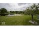 Peaceful community pond surrounded by lush greenery and a tree, creating a serene natural setting at 7657 Wheatgrass Ln, Noblesville, IN 46062