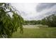 Scenic view of community pond fringed with greenery, creating a tranquil and picturesque landscape at 7657 Wheatgrass Ln, Noblesville, IN 46062