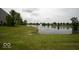 The property features a pond and large grassy area, complete with a charming water fountain feature at 7657 Wheatgrass Ln, Noblesville, IN 46062
