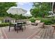 Inviting backyard features lounge furniture, dining table, and shade umbrellas on a wooden deck at 8436 N Meridian St, Indianapolis, IN 46260