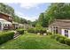 Sprawling backyard with manicured landscaping, wooden deck, and charming outbuilding, surrounded by mature trees at 8436 N Meridian St, Indianapolis, IN 46260
