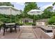 Inviting backyard features a dining table, lounge furniture, and shade umbrellas on a wooden deck at 8436 N Meridian St, Indianapolis, IN 46260