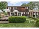 Backyard of a multi-story home with a wooden exterior, patio area, manicured lawn and lush surrounding greenery at 8436 N Meridian St, Indianapolis, IN 46260