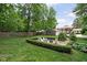 Expansive backyard with a cozy fire pit area, surrounded by manicured hedges and lush greenery at 8436 N Meridian St, Indianapolis, IN 46260