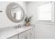 Bright bathroom features a vanity with marble counters, modern fixtures, and round mirror at 8436 N Meridian St, Indianapolis, IN 46260