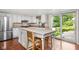 Bright kitchen features white cabinets, stainless steel appliances, tile backsplash, and breakfast bar with outdoor view at 8436 N Meridian St, Indianapolis, IN 46260