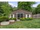 Rustic wooden outbuilding featuring a sliding glass door, complementing windows and lush greenery at 8436 N Meridian St, Indianapolis, IN 46260