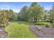 Large manicured backyard with lush green lawn, mature trees and tasteful landscaping at 8712 Admirals Bay Dr, Indianapolis, IN 46236