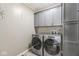 Functional laundry room featuring modern washer and dryer units with gray cabinets at 8712 Admirals Bay Dr, Indianapolis, IN 46236