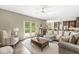 Bright living room featuring a comfortable gray sofa, access to the backyard, and a view of the kitchen at 8712 Admirals Bay Dr, Indianapolis, IN 46236