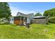 Charming home exterior showcasing a lush green yard, mature trees, and a detached garage at 89 S Grant St, Martinsville, IN 46151