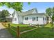 Home exterior showcasing a fenced yard, mature trees, and attractive landscaping at 89 S Grant St, Martinsville, IN 46151