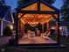 Relaxing backyard patio with wooden pergola, string lights, and comfortable chairs offers a perfect spot for outdoor enjoyment at 900 W Busby St, Lebanon, IN 46052