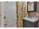 This bathroom has a floral shower curtain, tiled shower and black vanity at 900 W Busby St, Lebanon, IN 46052