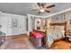 Bedroom with wood floors, ceiling fan, paneled accent wall, and a barn door to the en-suite bathroom at 900 W Busby St, Lebanon, IN 46052