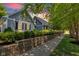 Charming home with beautiful landscaping, stone retaining wall, and gray siding with black shutters at 900 W Busby St, Lebanon, IN 46052