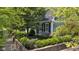 Charming home featuring mature landscaping, gray siding, and classic black shutters, creating a welcoming curb appeal at 900 W Busby St, Lebanon, IN 46052