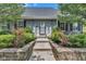 Charming entrance with gray door, shutters and mature shrubbery with red roses at 900 W Busby St, Lebanon, IN 46052