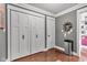 Hallway with paneled closet doors, stainless steel trash receptacle, dark wood flooring, and gray walls at 900 W Busby St, Lebanon, IN 46052