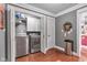 View of the laundry room with front-loading, stainless steel washer and dryer behind open closet doors at 900 W Busby St, Lebanon, IN 46052