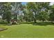 Lush backyard with mature trees and a charming playset at 9014 Holliday Dr, Indianapolis, IN 46260