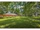 Expansive backyard with lush greenery, a playset, and mature trees at 9014 Holliday Dr, Indianapolis, IN 46260