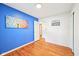 Cozy bedroom featuring blue accent wall, hardwood floors, and a bright window at 9014 Holliday Dr, Indianapolis, IN 46260