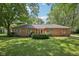 Charming brick home with a well-manicured lawn and mature trees, creating a welcoming curb appeal at 9014 Holliday Dr, Indianapolis, IN 46260