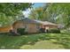 Side view of a beautiful brick home surrounded by lush greenery and well-maintained landscaping at 9014 Holliday Dr, Indianapolis, IN 46260