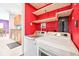 Bright laundry room with white washer and dryer and shelving for optimal organization and storage at 9014 Holliday Dr, Indianapolis, IN 46260