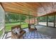Relaxing screened porch with wood ceiling, wicker furniture and backyard view at 9014 Holliday Dr, Indianapolis, IN 46260